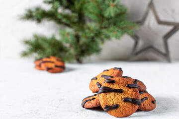 orange cookies with black stripes and fir tree branches. Christmas holiday sweet dessert. Concept for children new year