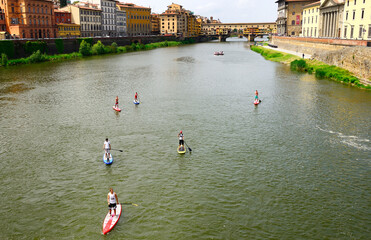 SUP -  paddle boarding, Arno river, in background Ponte Vecchio - Vecchio bridge, historic centre of Florence, World Heritage by UNESCO, Florence, Tuscany, Italy, Europe, EU