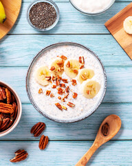 Banana and pecan nuts overnight oatmeal with chia seeds in bowl, rich in protein breakfast or snack