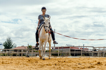 A woman taking horse riding lessons in a paddock