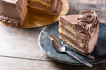 Piece of chocolate truffle cake on rustic wooden table