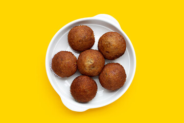 Banana Cupcakes in white plate on yellow background.