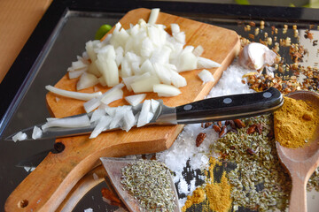 Cebolla picada con cuchillo sobre tabla de madera para cocinar comida vegana