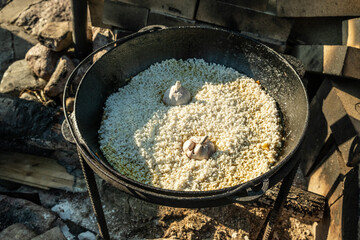 Cooking food on a fire, in a cauldron. Traditional Asian food is pilaf. Zirvak made from onions, oil, carrots, meat and spices. Mixed with rice. Prepared in a cauldron, over a fire. Birch firewood. Ru
