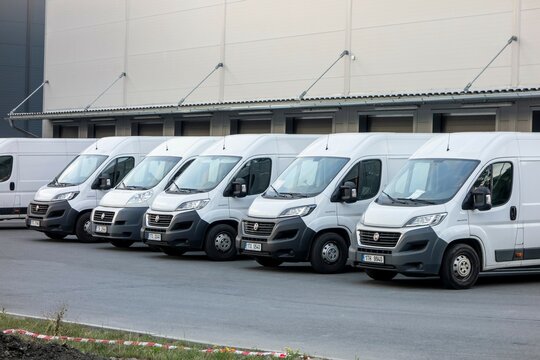 Several white Fiat Ducato vans loading cargo at Fedex depot