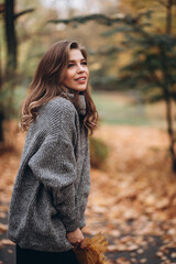 Obraz premium Portrait of a joyful young woman enjoying in the autumn park. beautiful blonde girl in autumn red beret and gray sweater. Relax in nature