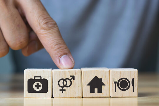 human hand placing cube with food Clothing, housing, medicine, four basic human needs concept.