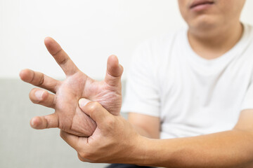 Asian middle-aged man patient suffering from numbing pain in hand,arthritis,tendon problem causing...