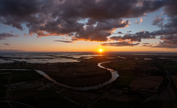 Luftaufnahme, Drohnenfoto, der Landschaft um Cabanes de Cambon in der N&auml;he von Saintes-Maries-de-la-Mer mit Blick &uuml;ber den Fluss kleine Rhone bis zum Mittelmeer, bei Sonnenuntergang mit dramatischen W