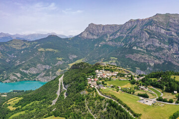 Drohnenaufnahme, Drohnenfoto der Bergwelt um die Kirche Saint Vincent Les Forts mit Blick auf den Stausee Ubaye Valley, Saint Vincent les Forts, Alpes-de-Haute-Provence, Frankreich