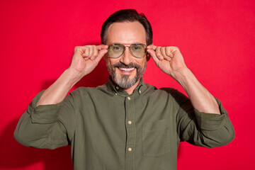 Fototapeta premium Photo of cool mature brunet man wear khaki shirt eyewear isolated on red color background