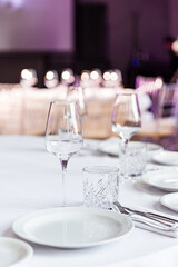 stylish empty glasses and plates at setting at elegant table for wedding reception, catering in restaurant