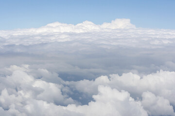 View from high altitude of fluffy and soft white cloud texture pattern like cotton, foam or snow. Use for wallpaper, background or backdrop. No people. Copy space. 