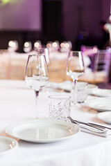 stylish empty glasses and plates at setting at elegant table for wedding reception, catering in restaurant