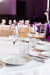 stylish empty glasses and plates at setting at elegant table for wedding reception, catering in restaurant