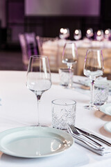 stylish empty glasses and plates at setting at elegant table for wedding reception, catering in restaurant