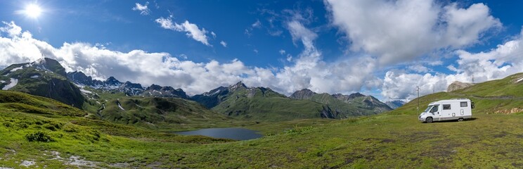 Panoramafoto, Wohnmobil beim Wildcamping vor einem Bergsee und Bergpanorama, französische Alpen, im Hintergrund das Bergmassiv vom Mont Blanc, mit Wolken und blauem Himmel, Séez, Département Savoie, 