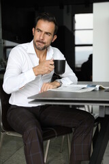 Fototapeta Poranna prasa i praca podczas pierwszej kawy. Przystojny mężczyzna w białej koszuli pije poranną kawę.  obraz