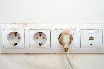 dirty dust on the power socket or connector and electric wire in the room. real old neglected dusty...