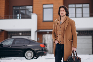 Fototapeta na wymiar Young handsome business man walking out of the house to his car