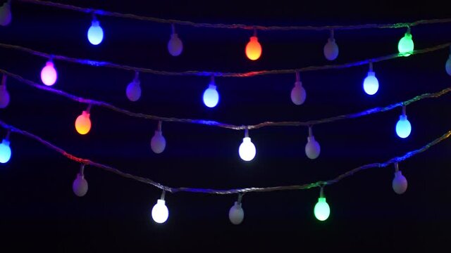 Colorful Christmas holiday lights string blinking isolated on black background