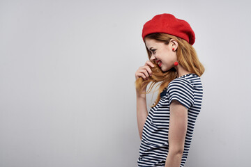 Naklejka premium pretty woman in a striped t-shirt red lips gesture with his hands light background