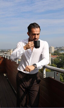 Fototapeta Przystojny brunet w białej koszuli podczas porannej kawy przed wyjściem do pracy.