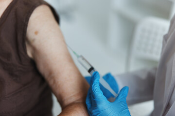 doctor makes an injection in the arm immunity protection covid passport close-up