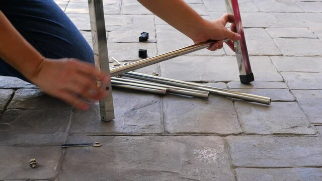 Man doing DIY assembly steel table frame home furniture interia decoration