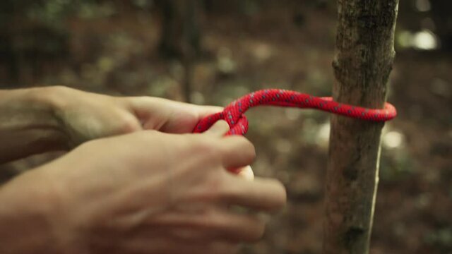 Man ties a safety rope around the harness before top rope climbing