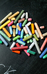 Colored chalks aligned on blackboard
