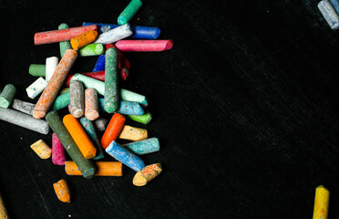Colored chalks aligned on blackboard
