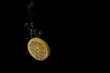 Fresh fruit fall into the cold water with air bubbles as symbol for healthy vegan lifestyle in short time exposure of high speed camera