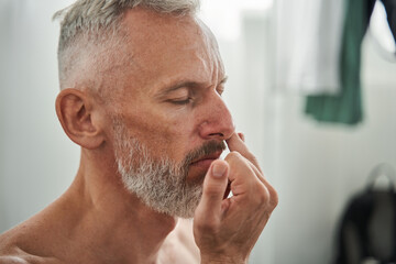 Close up of mature man sniff something with nose