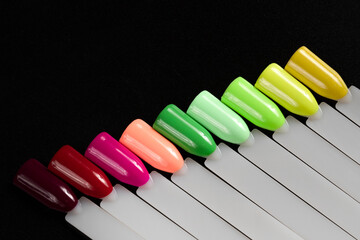 Multiсolor nail tips on a black background. examples of manicure for nails. Palette with color samples of nail. Copy space