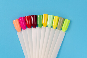 Multiсolor nail tips on a blue background. examples of manicure for nails. Palette with color samples of nail. Copy space