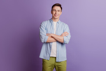 Portrait of charming succsessful self-assured guy folded hands toothy smile on purple background