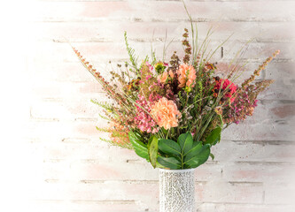 Autumn floral pink and orange decoration on a brick wall background