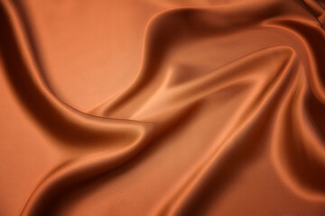 Texture, background, pattern. Texture of yellow or orange silk fabric. Beautiful soft silk fabric.