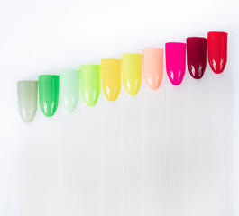 Fototapeta premium Multiсolor nail tips on a white background. examples of manicure for nails. Palette with color samples of nail. Copy space