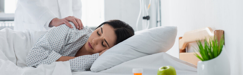 doctor waking up brunette patient in hospital bed, banner