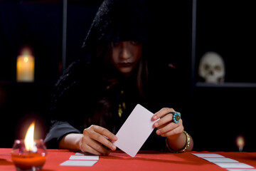 Dark witch in black hood holding magical card, mysterious magnificent beautiful woman fortune...