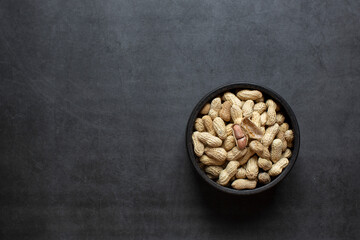 peanuts in bowl on dark grey background