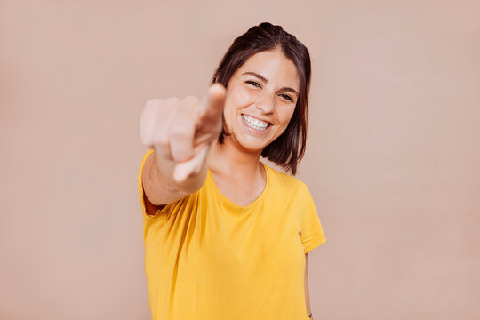 Smiling woman point finger at you, positive mood.