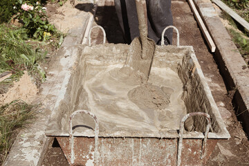 Kneading cement for pouring garden path, garden construction work
