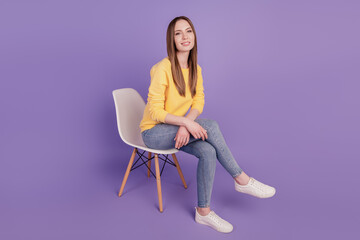 Fototapeta na wymiar Portrait of inspired lady sit chair look camera posing white beaming smile on violet background