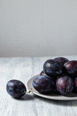 Fresh plums. Fruits. On a white wooden background. Copy space.