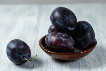 Fresh plums. Fruits. On a white wooden background. Copy space.
