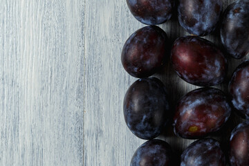 Fresh plums. Fruits. On a white wooden background. Copy space.