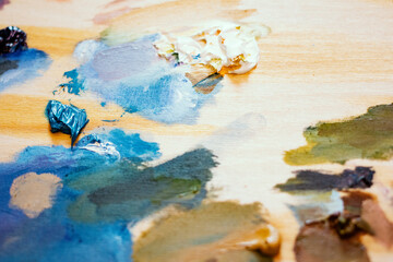 Oil paints. Artist's wooden palette with vibrant paint strokes. Beautiful art background.